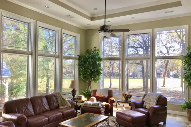 Bright living room with large floor-to-ceiling windows secured by Crimsafe Safe-S-Cape screens, combining open views with home protection.