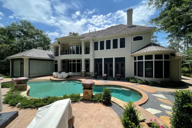 Luxury two-story home with Crimsafe security screens installed on all rear windows and doors overlooking a private backyard pool, combining elegant design with advanced protection.